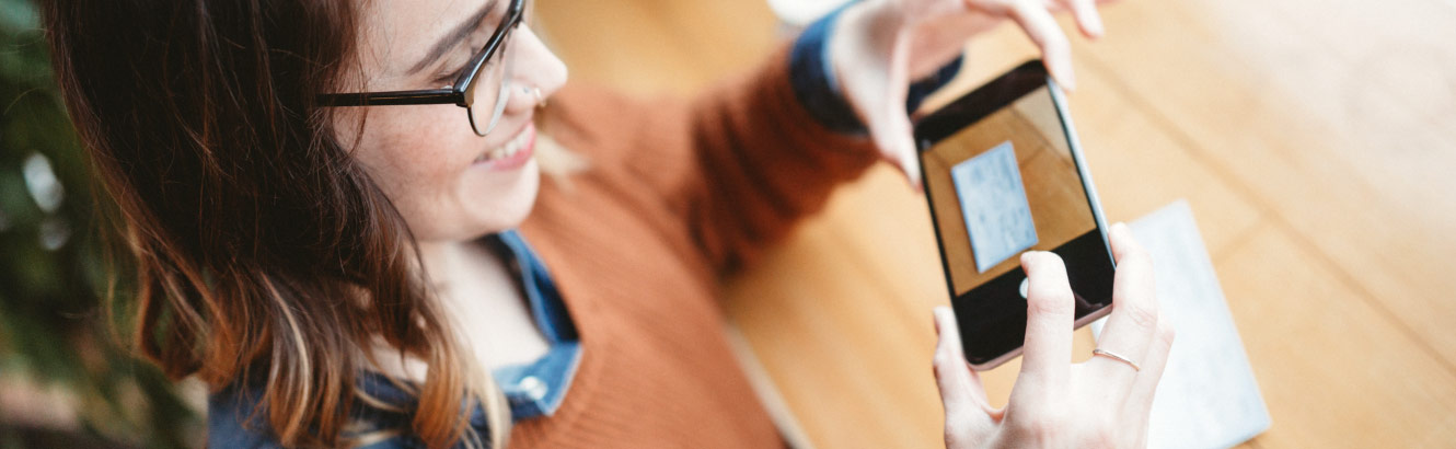 a girl depositing a check with her mobile phone