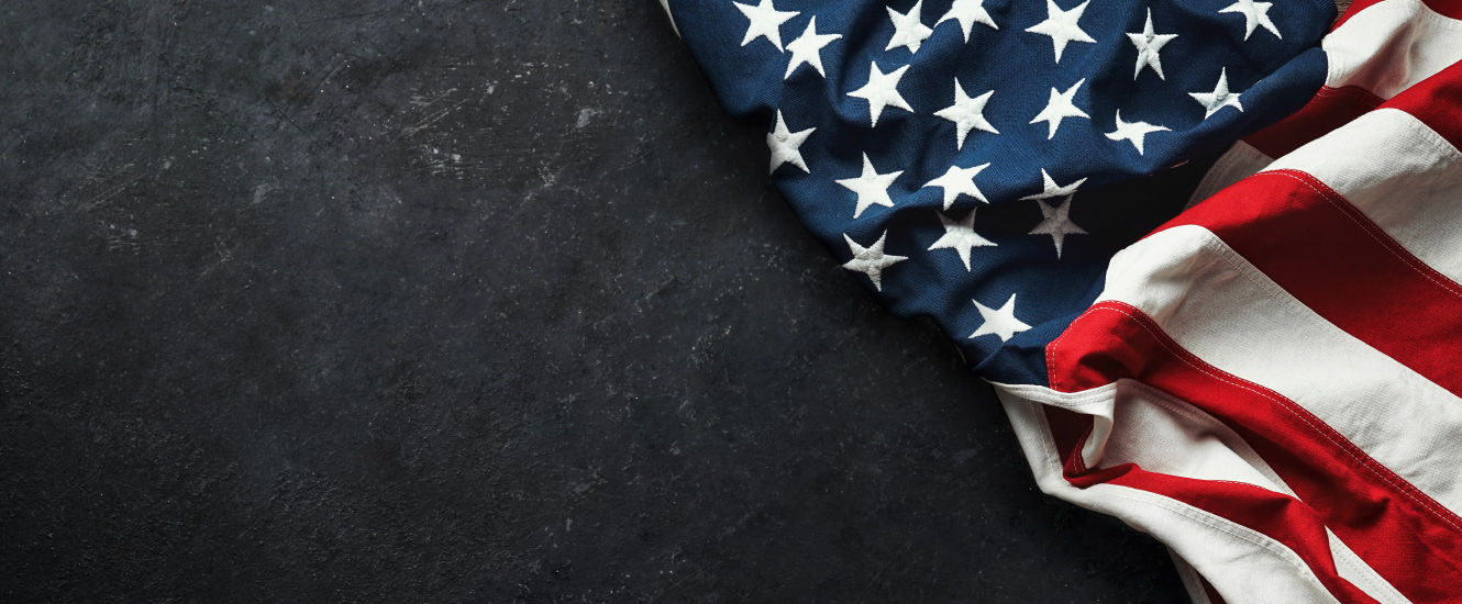 black background and American flag draped in the corner